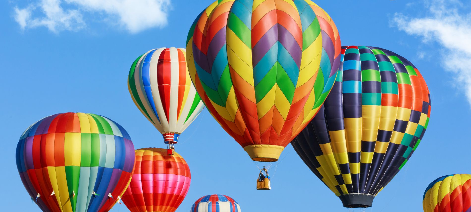 A view of numerous colorful hot air balloons lifting into the sky